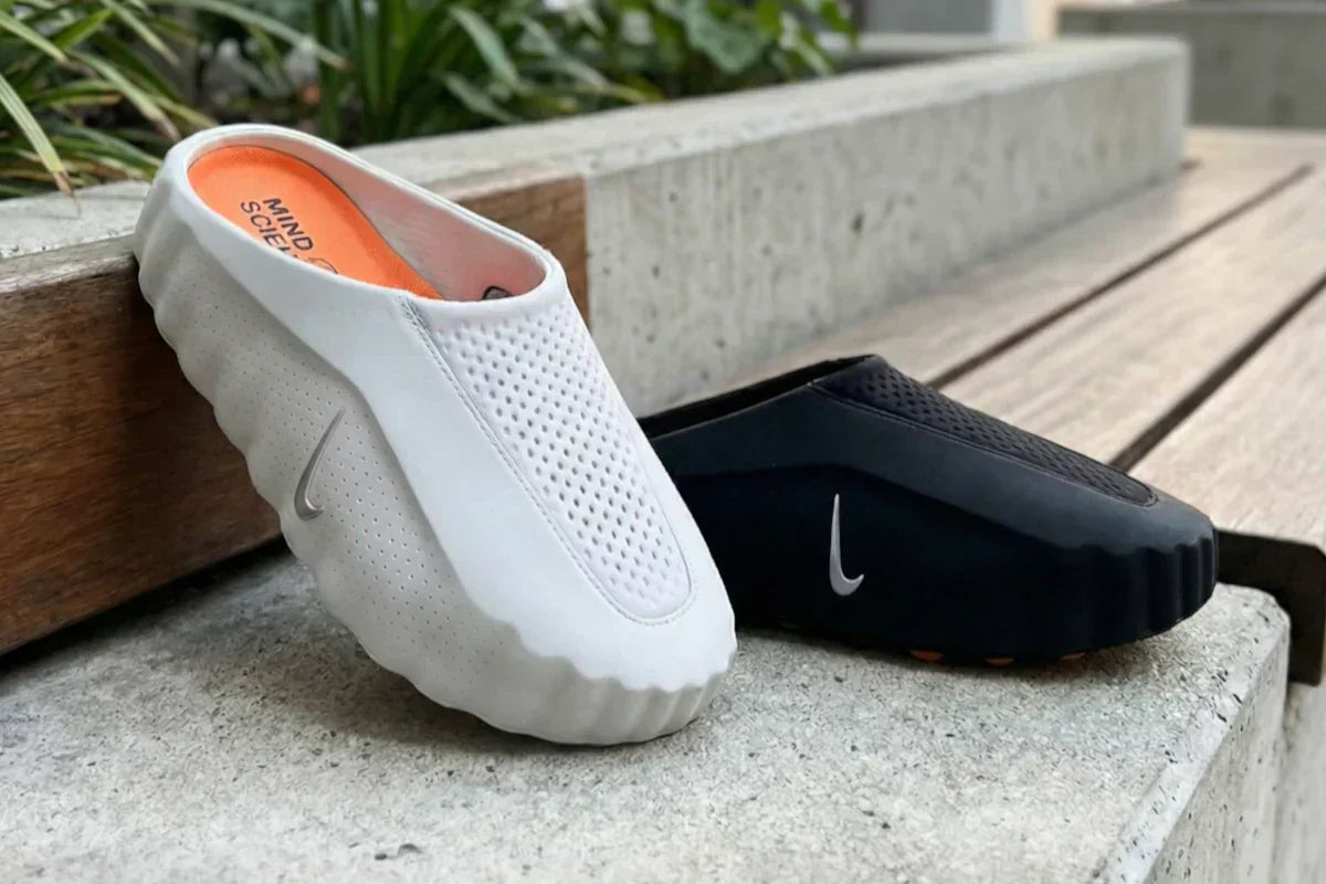 Nike Mind 001 Mule w kolorze białym i czarnym – test i opinie. Buty ustawione na betonowym murku.